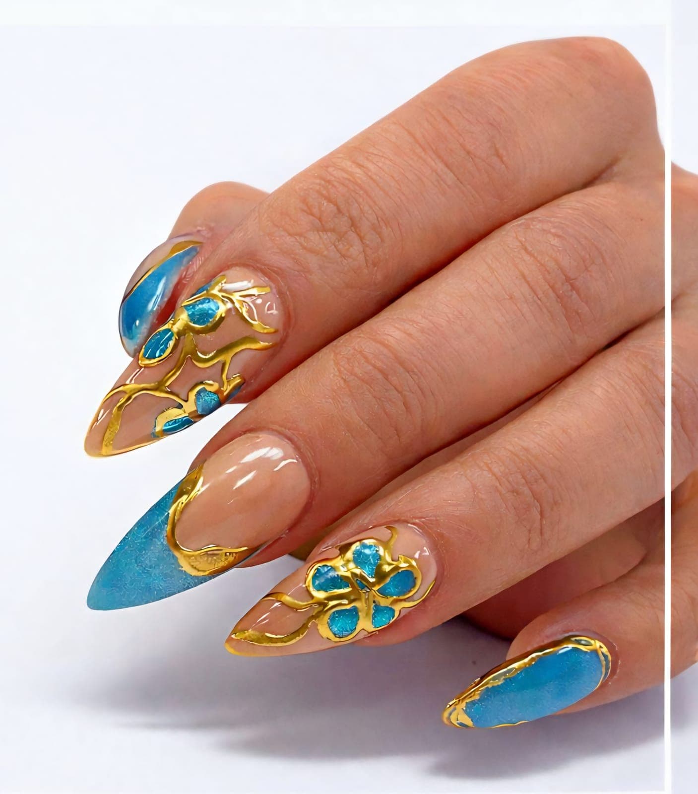 Blue and gold almond nails with a flower
