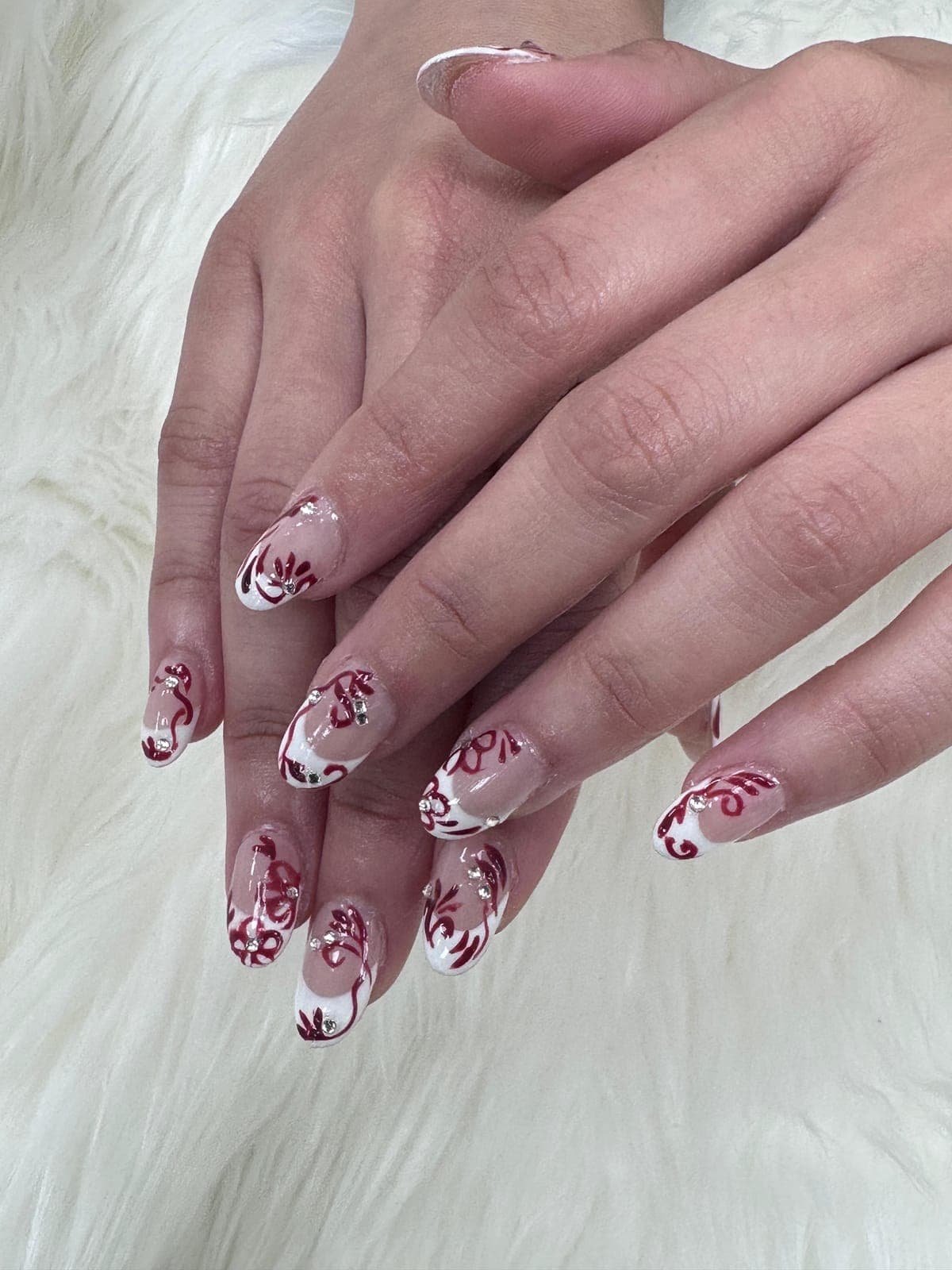 Almond nails with hand-painted burgundy flowers