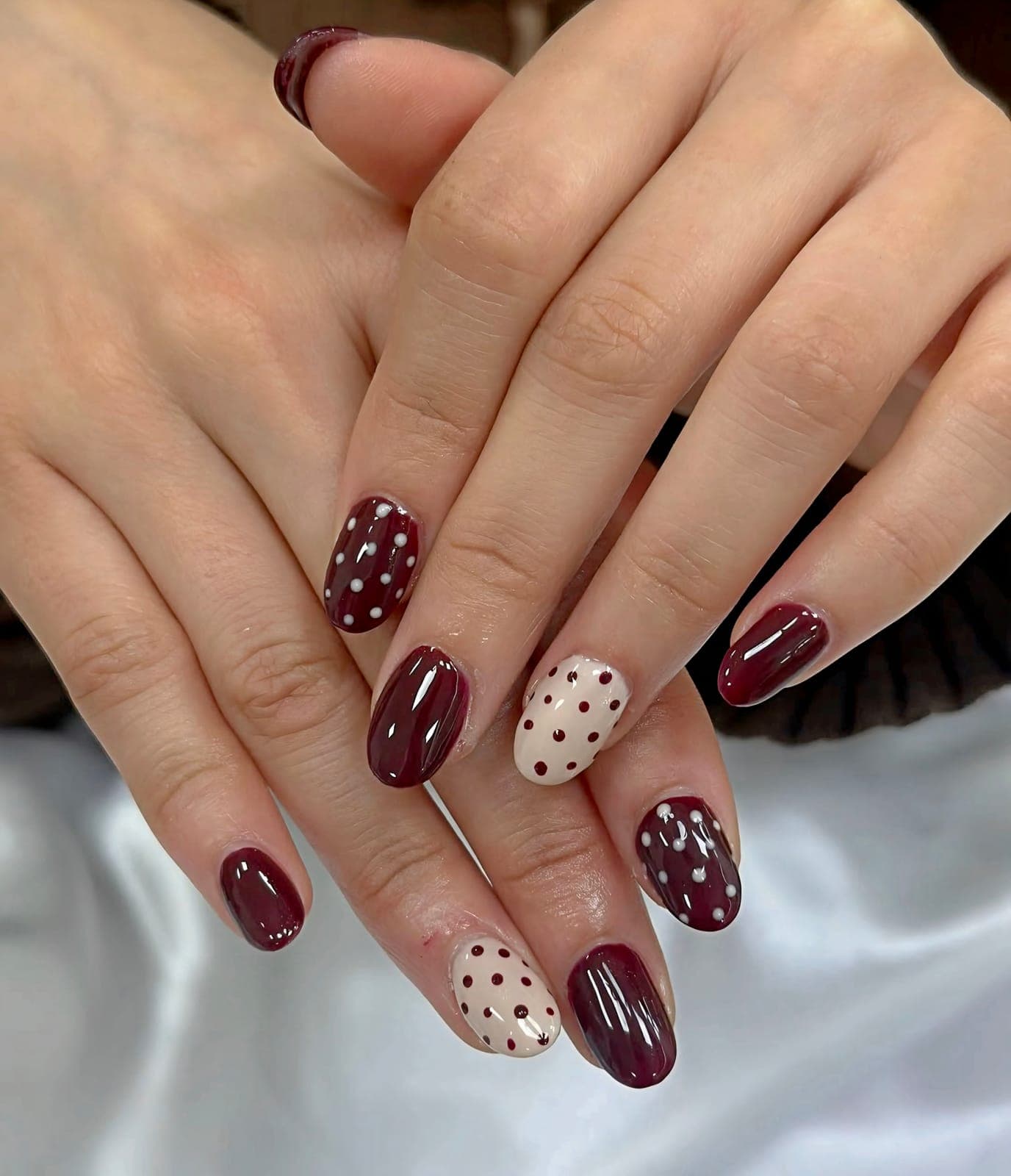 Short burgundy nails with polka dot accents
