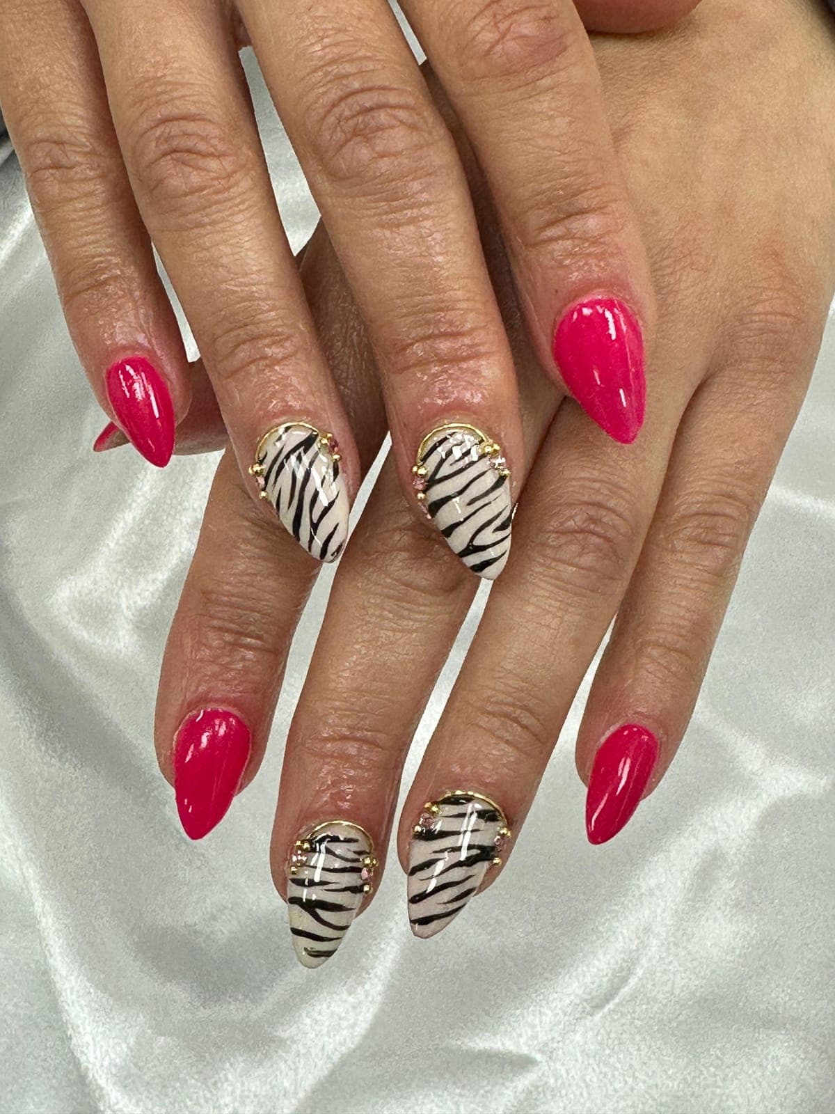 Hot pink almond nails with zebra print accents
