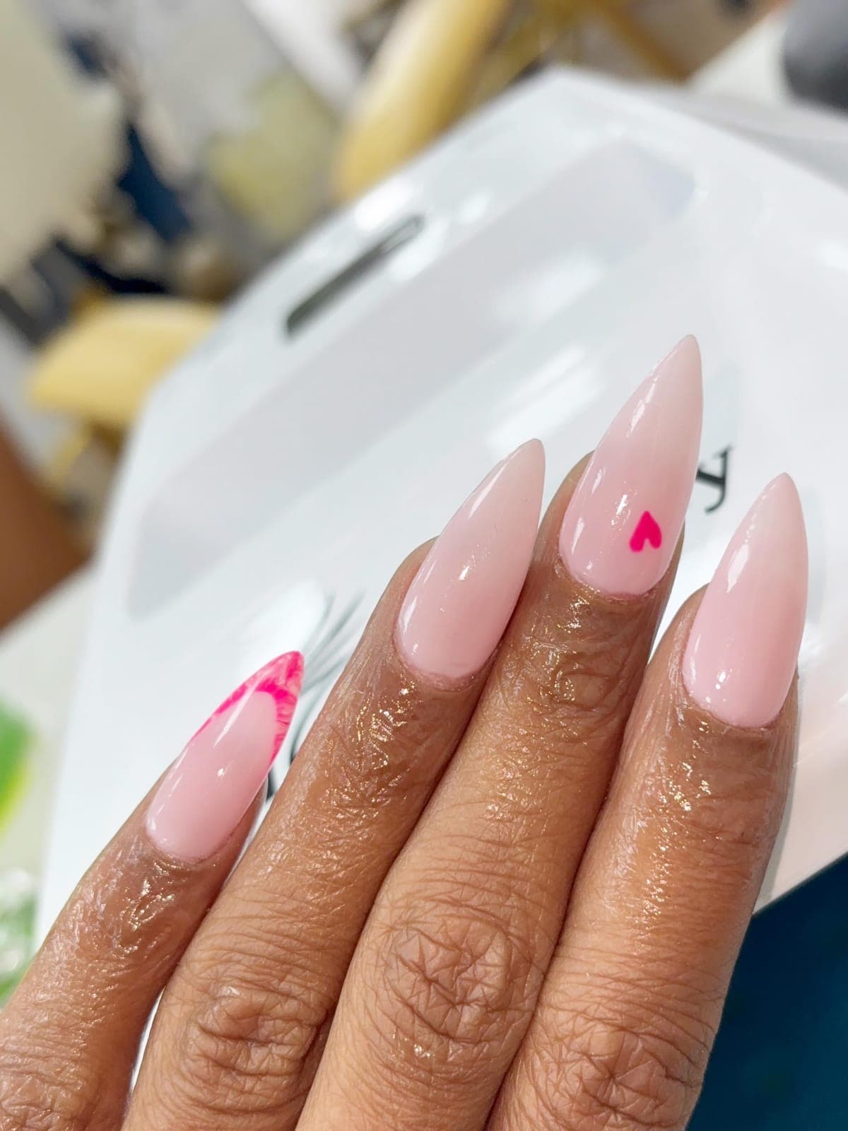 Nude almond nails with a small heart