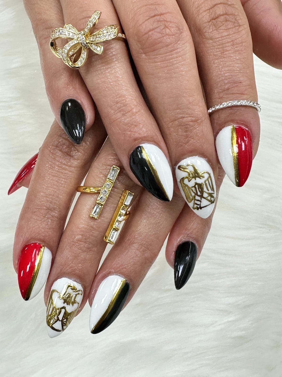 Red, black and white almond nails with gold charms