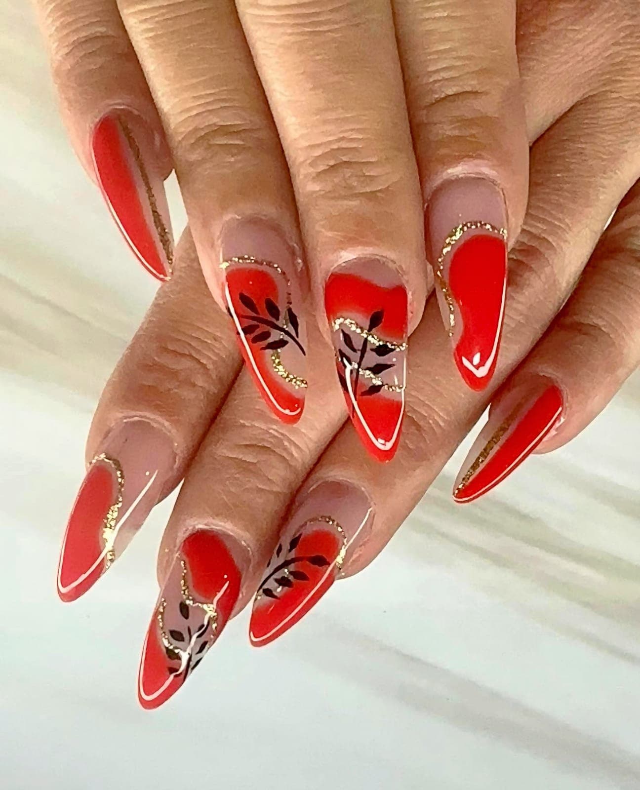 Red almond nails with hand-painted leaves