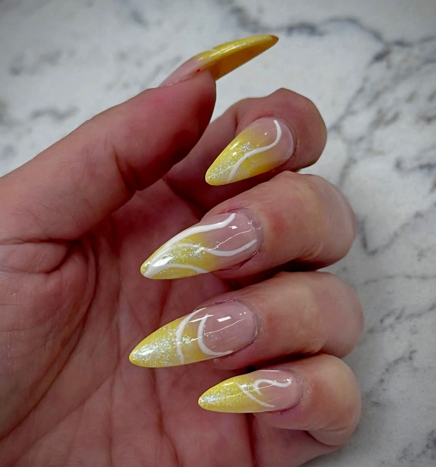 Yellow almond nails with white swirls